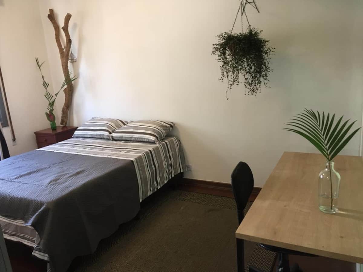 Cama de casal e mesa de trabalho na Suíte 15