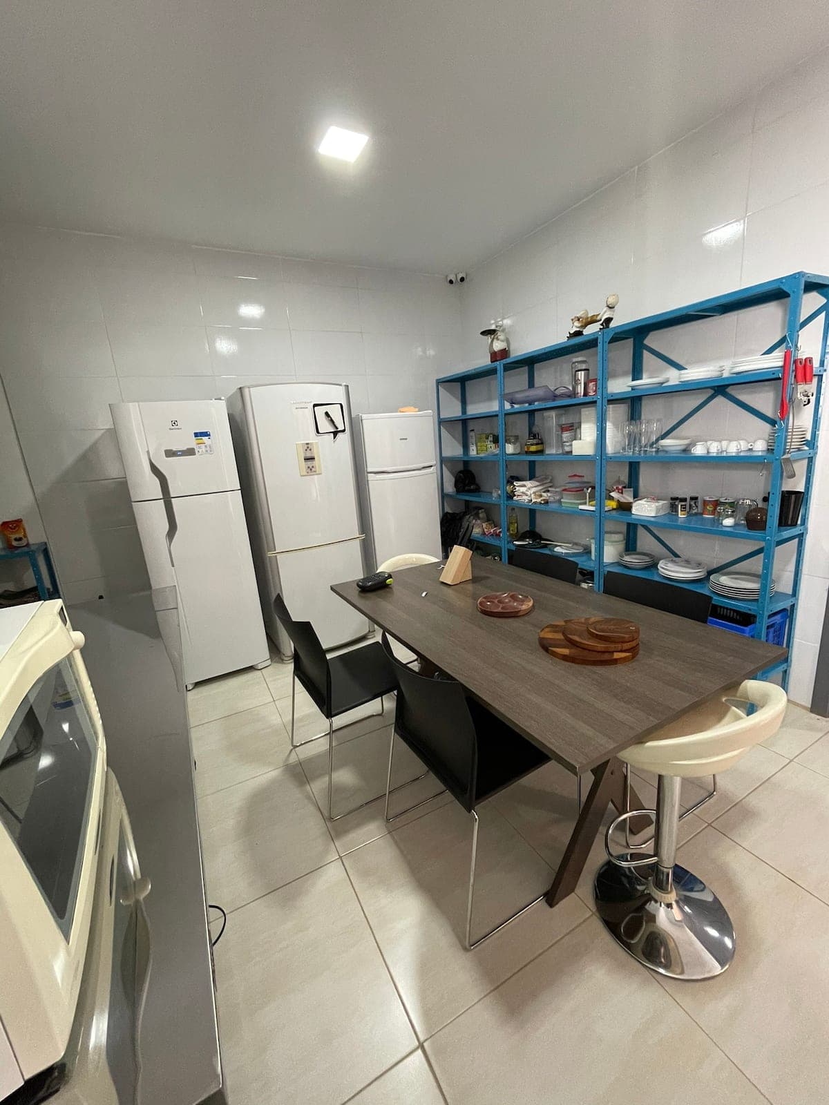 Cozinha compartilhada com mesa e geladeiras